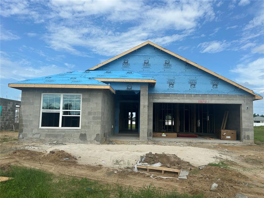A newly constructed single-story house with a stucco exterior and an unfinished front yard — 12535 NE 48TH TERRACE, OXFORD, FL