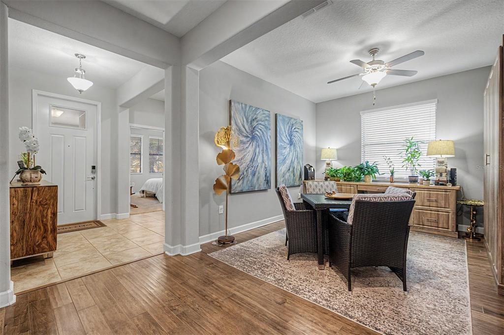 A dining area with a dark wicker table set sits beside an entryway with tile — 4926 SOUTHERN VALLEY LOOP, BROOKSVILLE, FL