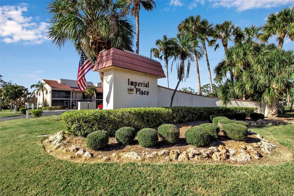 A sign for Imperial Place stands in front of a multi-story apartment building with palm trees — 5420 SWIFT ROAD UNIT 38, SARASOTA, FL
