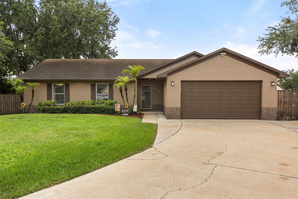 A single-story house with a brown stucco exterior, a two-car garage, and a front lawn — 4608 STURBRIDGE COURT, ORLANDO, FL