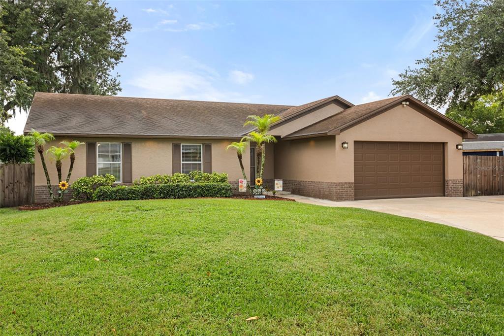 A single-story house with a brown roof, tan stucco exterior, and a two-car garage — 4608 STURBRIDGE COURT, ORLANDO, FL
