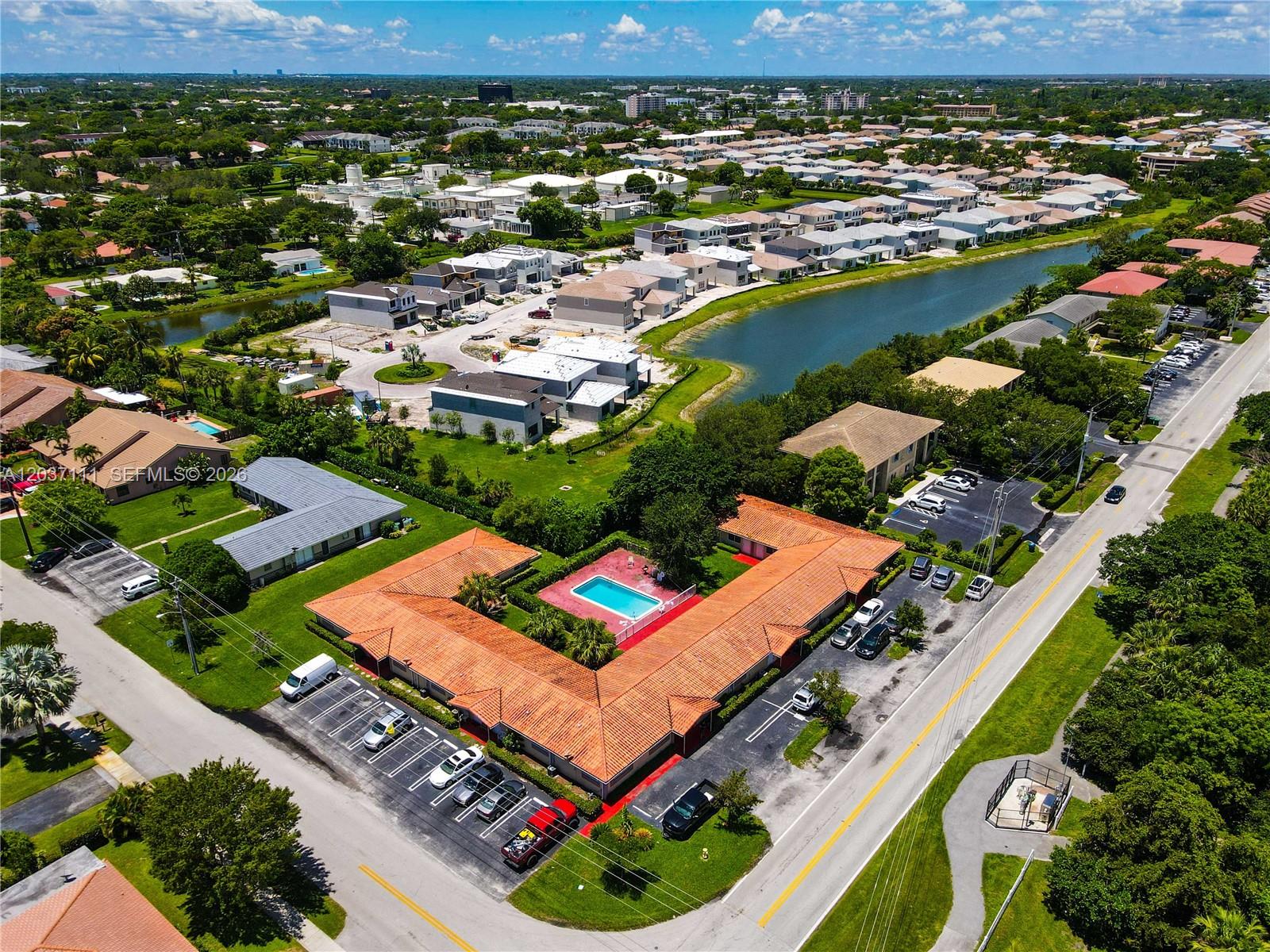 An aerial view shows a U-shaped building with a central pool and surrounding parking lots — CORAL SPRINGS, FL
