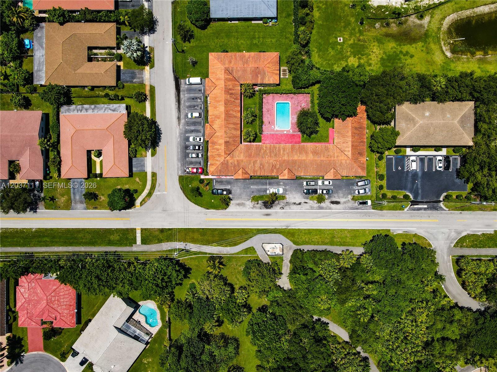 Aerial view of a U-shaped building with a central pool and surrounding parking lots — CORAL SPRINGS, FL