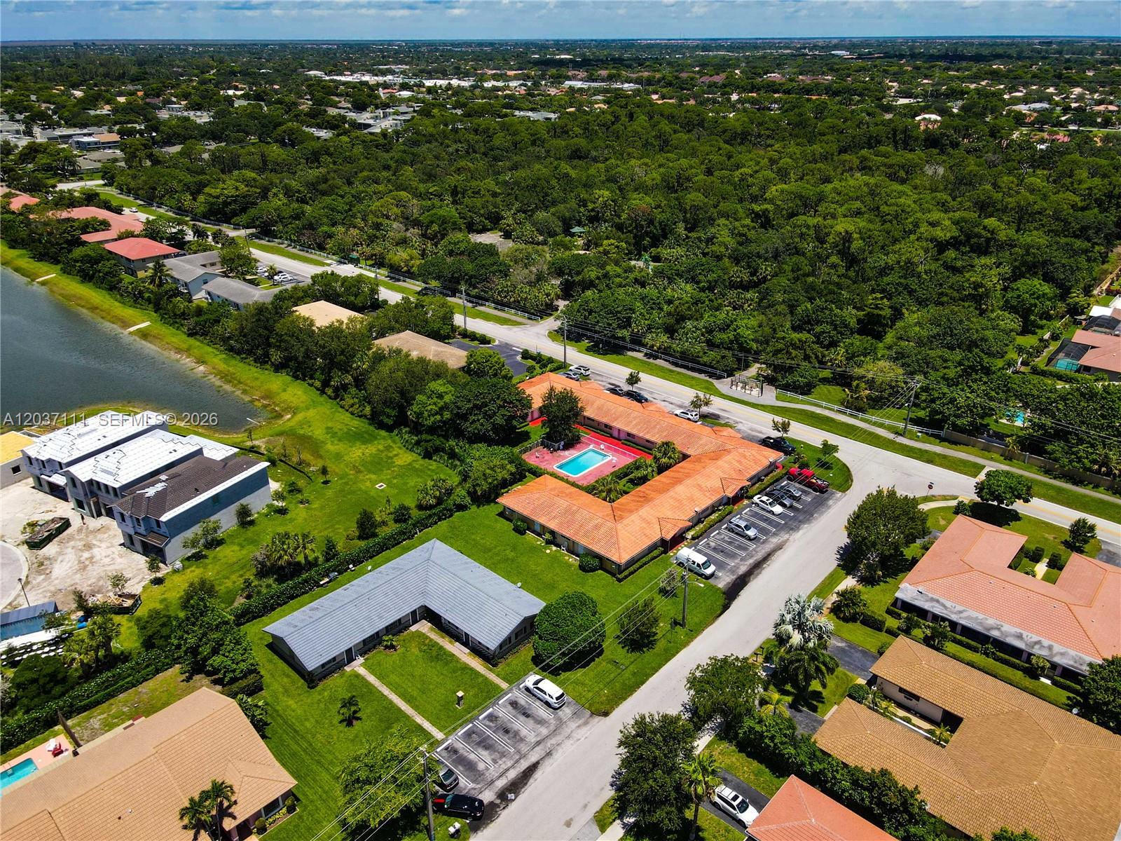 An aerial view shows a residential complex with a central pool and surrounding parking lots — CORAL SPRINGS, FL