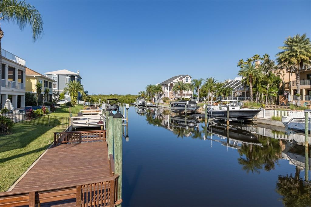A canal lined with boat docks and residential homes under a clear blue sky — 4335 SANDDOLLAR COURT, NEW PORT RICHEY, FL
