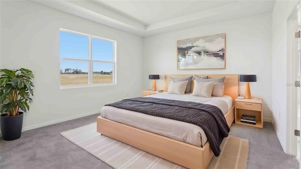 A bedroom features a light wood bed frame, two nightstands, and a window overlooking fields — 8172 IVES PLACE, WILDWOOD, FL