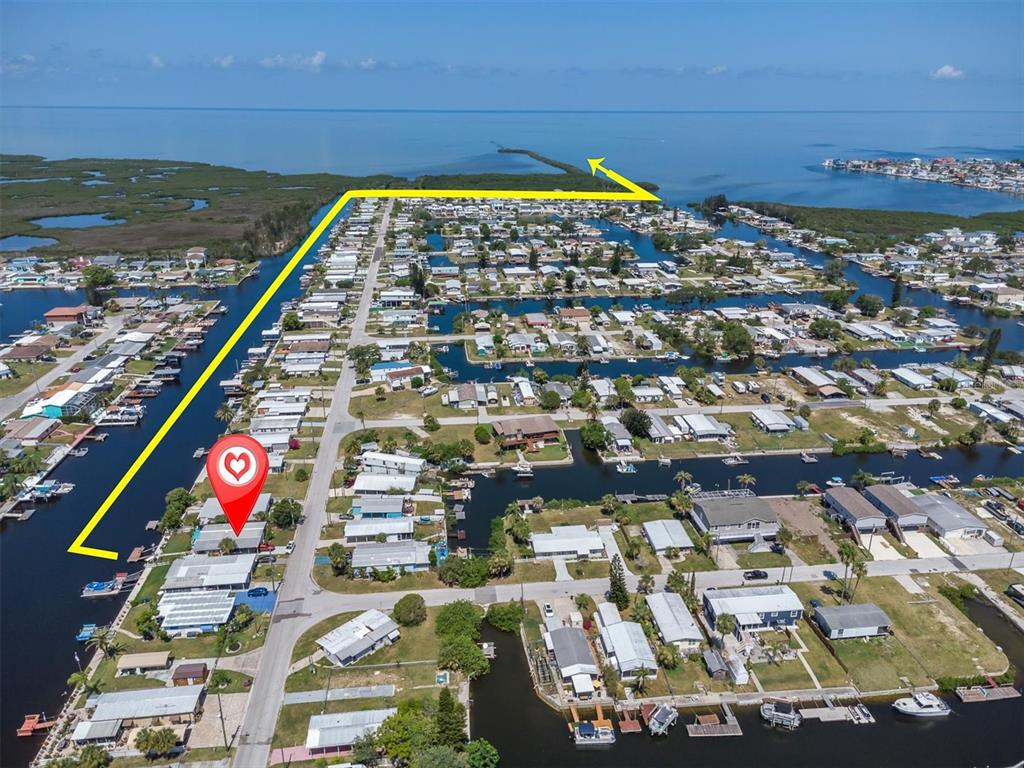 An aerial view shows a waterfront mobile home community with canals and a marked property — 6630 TOWER DRIVE, HUDSON, FL