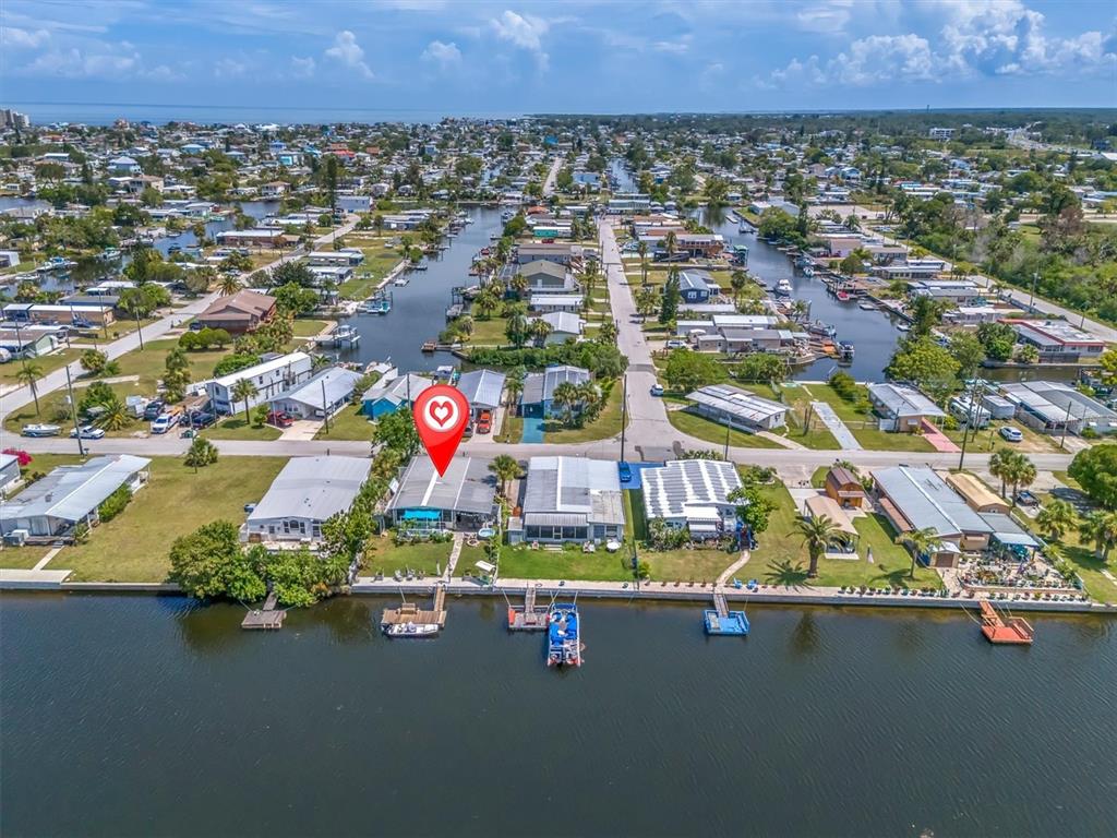 An aerial view shows a waterfront home with a private dock on a canal — 6630 TOWER DRIVE, HUDSON, FL