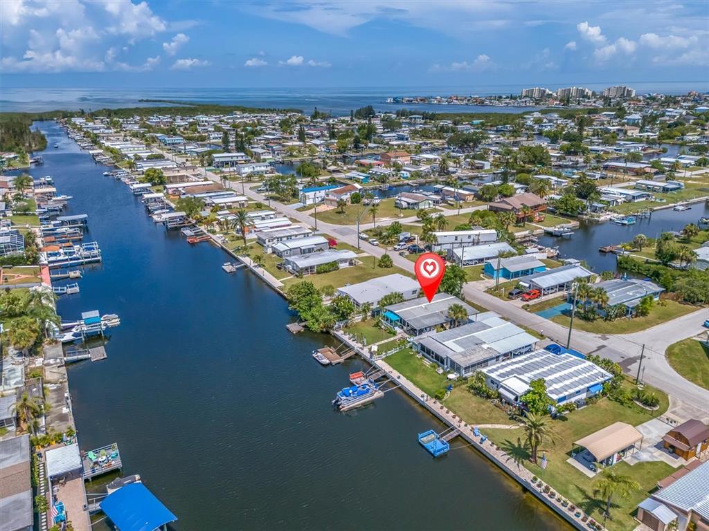An aerial view shows a waterfront house with a boat dock along a canal — 6630 TOWER DRIVE, HUDSON, FL