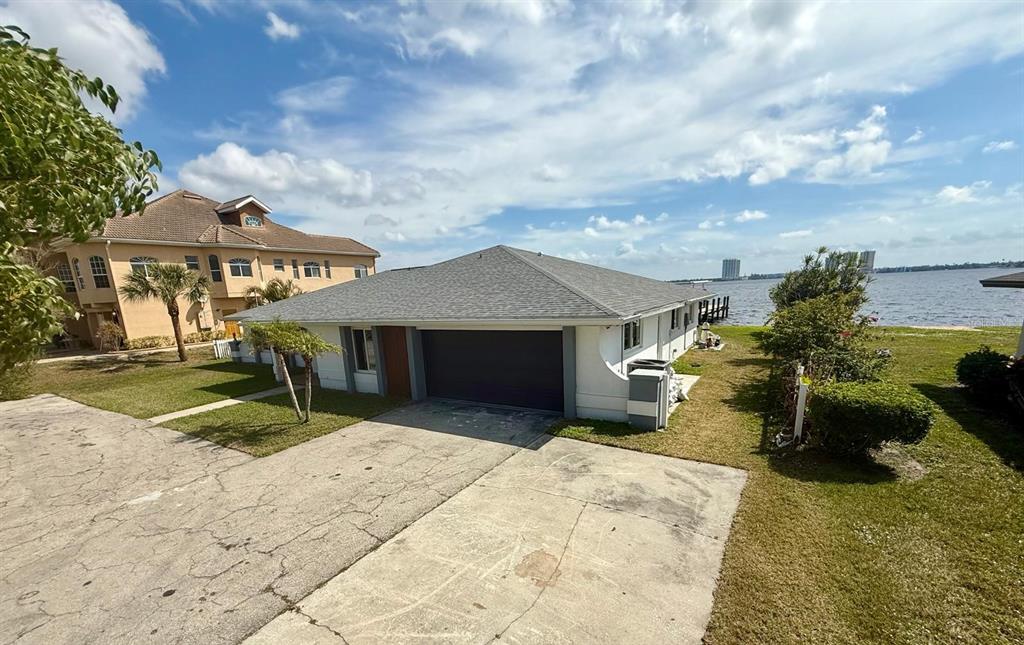 A one-story house with a garage and a driveway sits along a waterfront property — 111 E NORTH SHORE AVENUE, NORTH FORT MYERS, FL