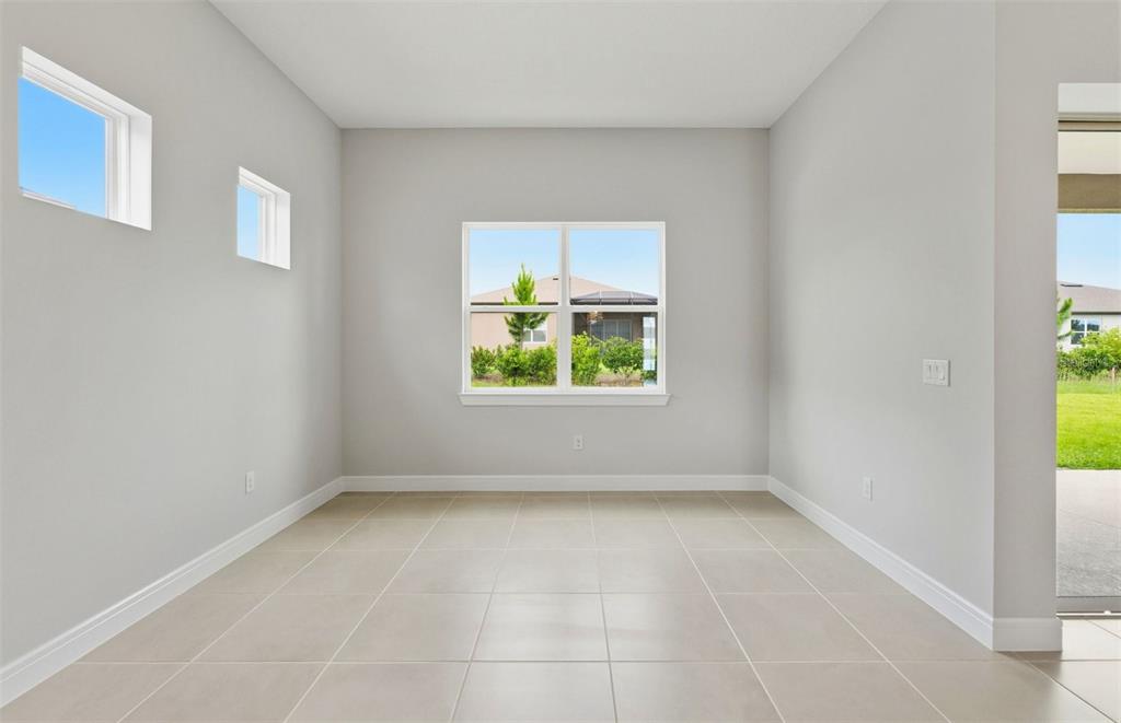 An empty room with light gray walls, tile flooring, and multiple windows — 6200 SW 82ND TERRACE ROAD, OCALA, FL