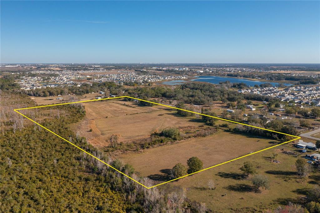 An aerial view shows a large, rectangular plot of open land outlined in yellow — 601 DIAMOND ACRES ROAD, DAVENPORT, FL