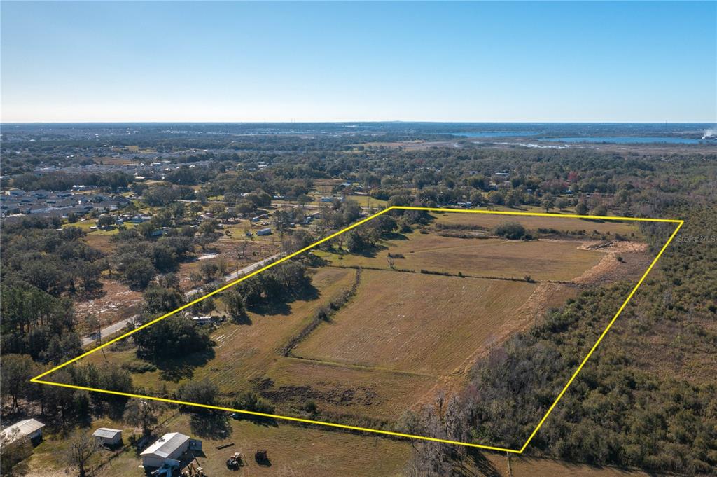 An aerial view shows a large, rectangular plot of open land outlined in yellow — 601 DIAMOND ACRES ROAD, DAVENPORT, FL
