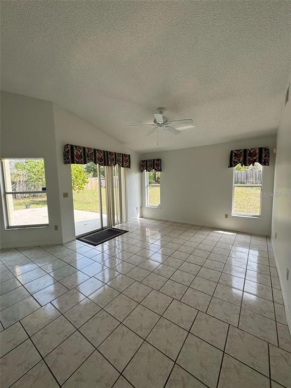 A bright living room features light-colored tile flooring, a ceiling fan, and sliding glass doors — 6724 CALLIE ROAD, ORLANDO, FL