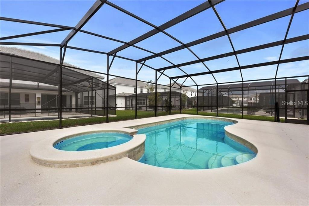 A screened-in patio features a swimming pool with an attached circular spa on a concrete deck — 2626 CALISTOGA AVENUE, KISSIMMEE, FL