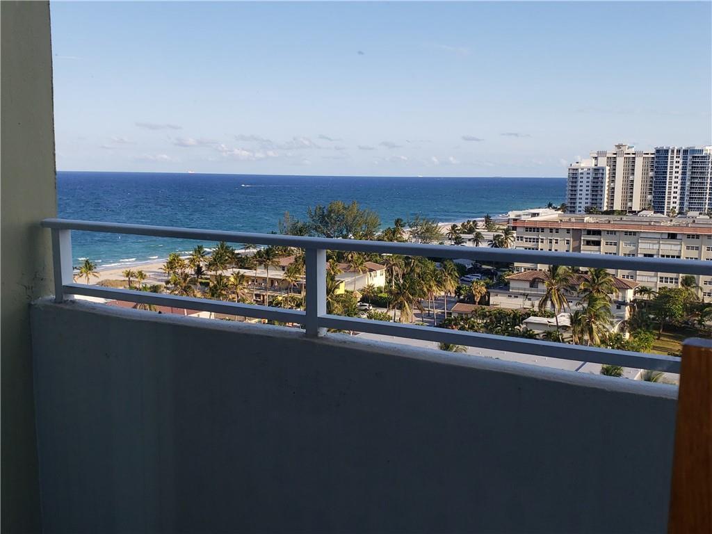 A balcony view overlooking a sandy beach, palm trees, and coastal high-rise buildings — 111 Briny Avenue # 1214, Pompano Beach FL 33062, POMPANO BEACH, FL