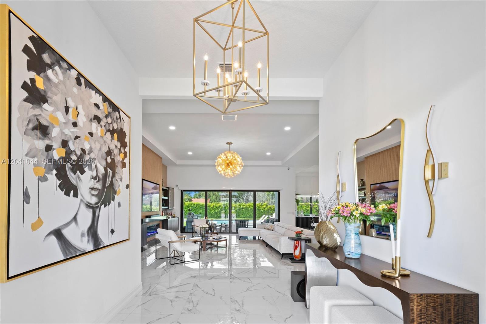 A bright, modern foyer leads into an open-concept living room with marble floors and chandeliers — 14850 Millstone Ranches Dr, Davie FL 33331, DAVIE, FL