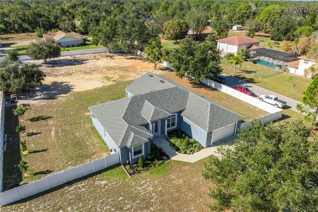 An aerial view shows a single-story house with a gray roof and a fenced yard — 2502 LAKE FRONT DRIVE, LAKE WALES, FL