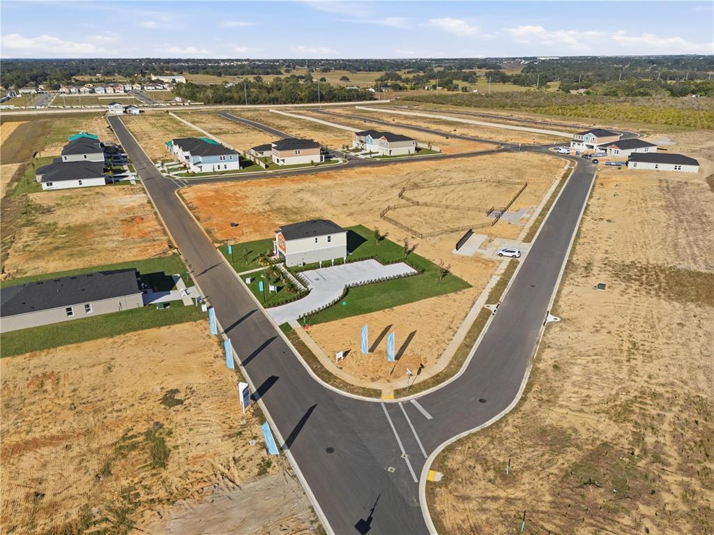 An aerial view shows a new residential development with several houses under construction on dirt lots — 4353 RIVERBEND BOULEVARD, HAINES CITY, FL