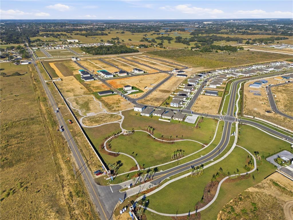 An aerial view shows a new residential housing development under construction with paved roads — 4353 RIVERBEND BOULEVARD, HAINES CITY, FL