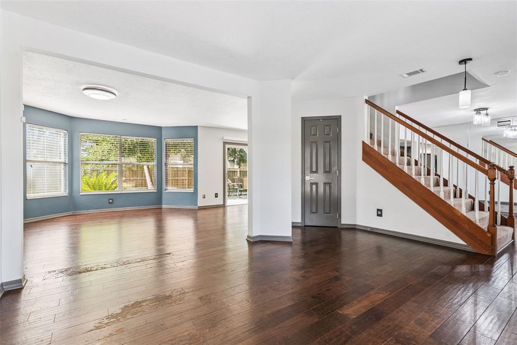 An interior view of a living area with hardwood floors, a staircase, and blue walls — 440 BUCKSKIN COURT, WINTER SPRINGS, FL