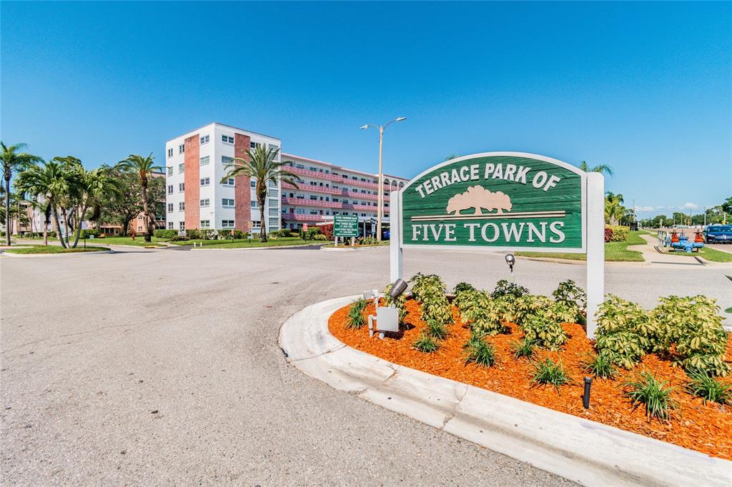 A green sign for Terrace Park of Five Towns stands before a multi-story apartment building — 5501 80TH STREET N UNIT 102, ST PETERSBURG, FL