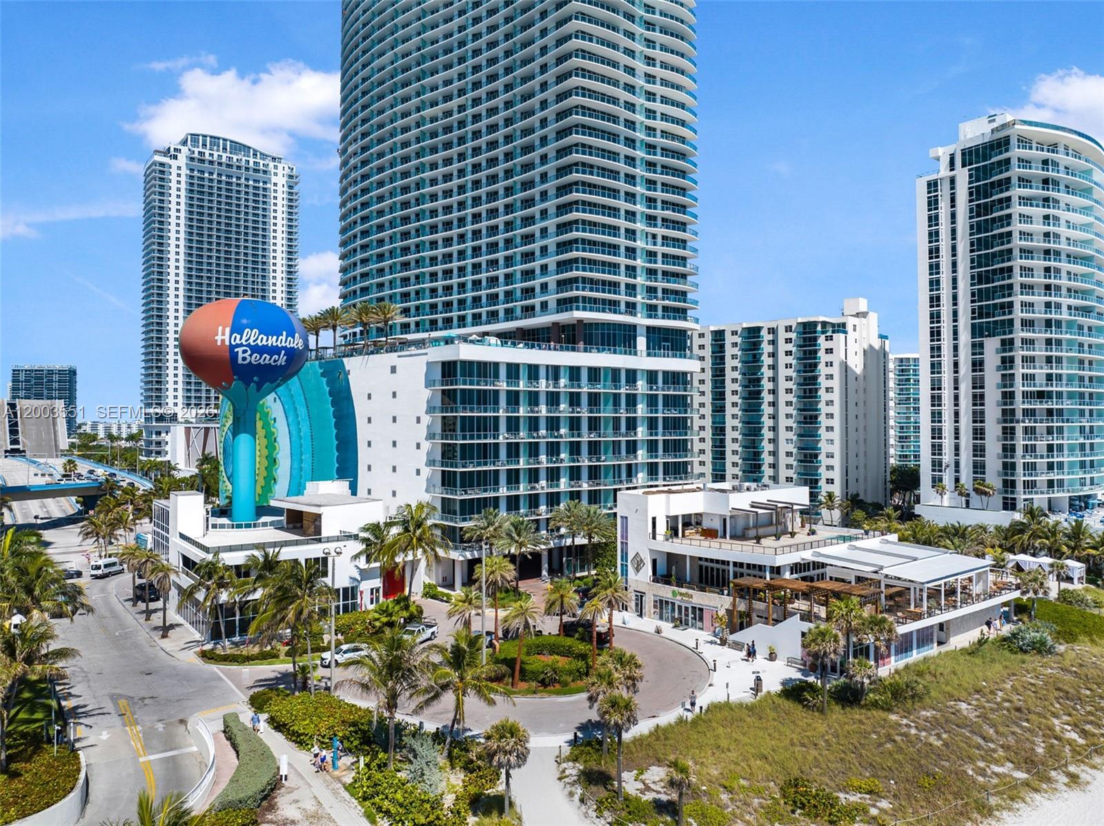 An aerial view shows a tall residential tower, a Hallandale Beach water tower, and landscaping — 4111 S Ocean Dr # 2207, Hollywood FL 33019, HOLLYWOOD, FL