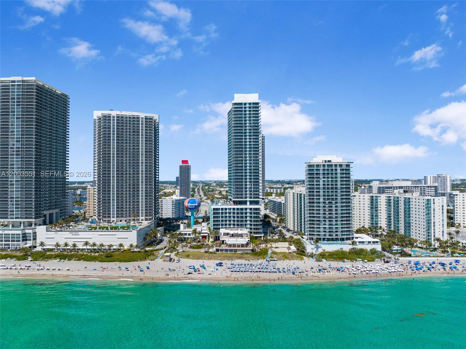 An aerial view shows high-rise buildings along a sandy beach with turquoise ocean water — 4111 S Ocean Dr # 2207, Hollywood FL 33019, HOLLYWOOD, FL