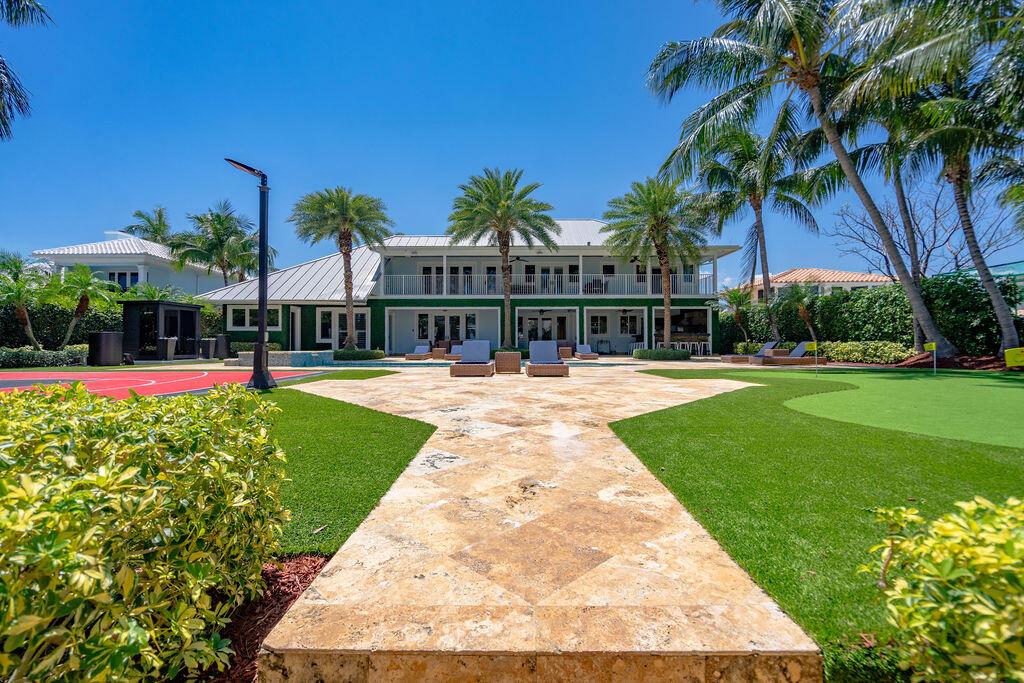 A backyard features a stone patio, a putting green, a basketball court, and a two-story house — 4130 NE 31st Avenue, Lighthouse Point FL 33064, LIGHTHOUSE POINT, FL