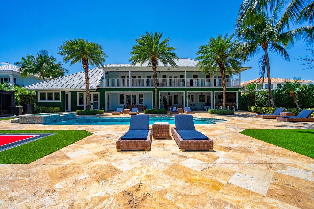 A two-story house with a pool, patio, and palm trees under a clear blue sky — 4130 NE 31st Avenue, Lighthouse Point FL 33064, LIGHTHOUSE POINT, FL