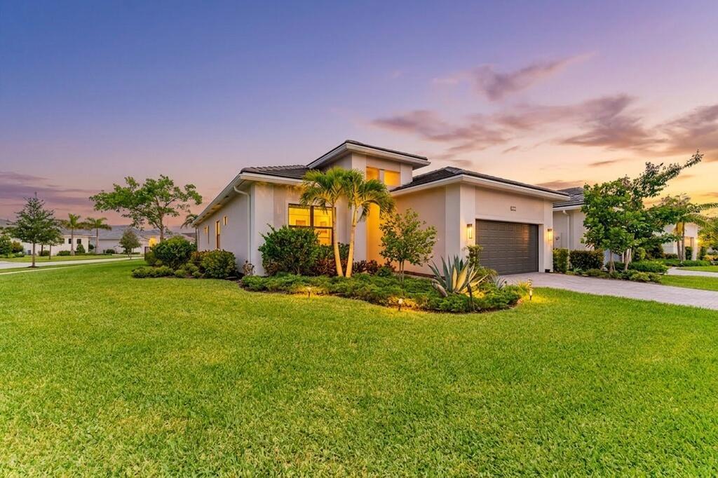 A single-story house with a garage and landscaped lawn at sunset — 15665 Merritt Drive, Westlake FL 33470, WESTLAKE, FL
