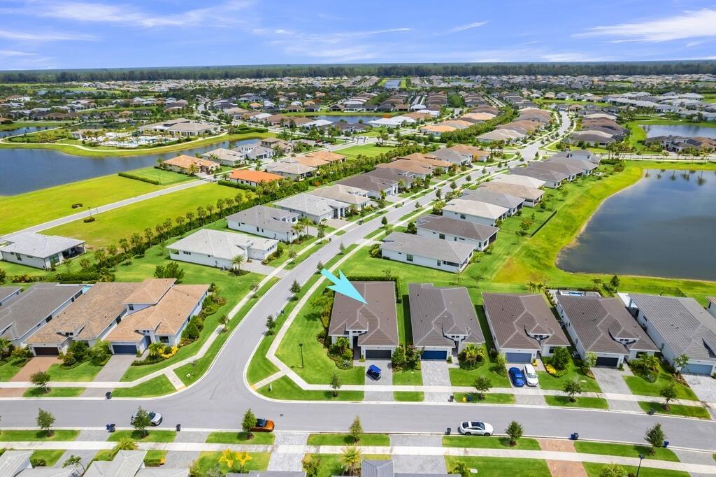 An aerial view shows a suburban neighborhood with houses, lawns, and a nearby lake — 15665 Merritt Drive, Westlake FL 33470, WESTLAKE, FL