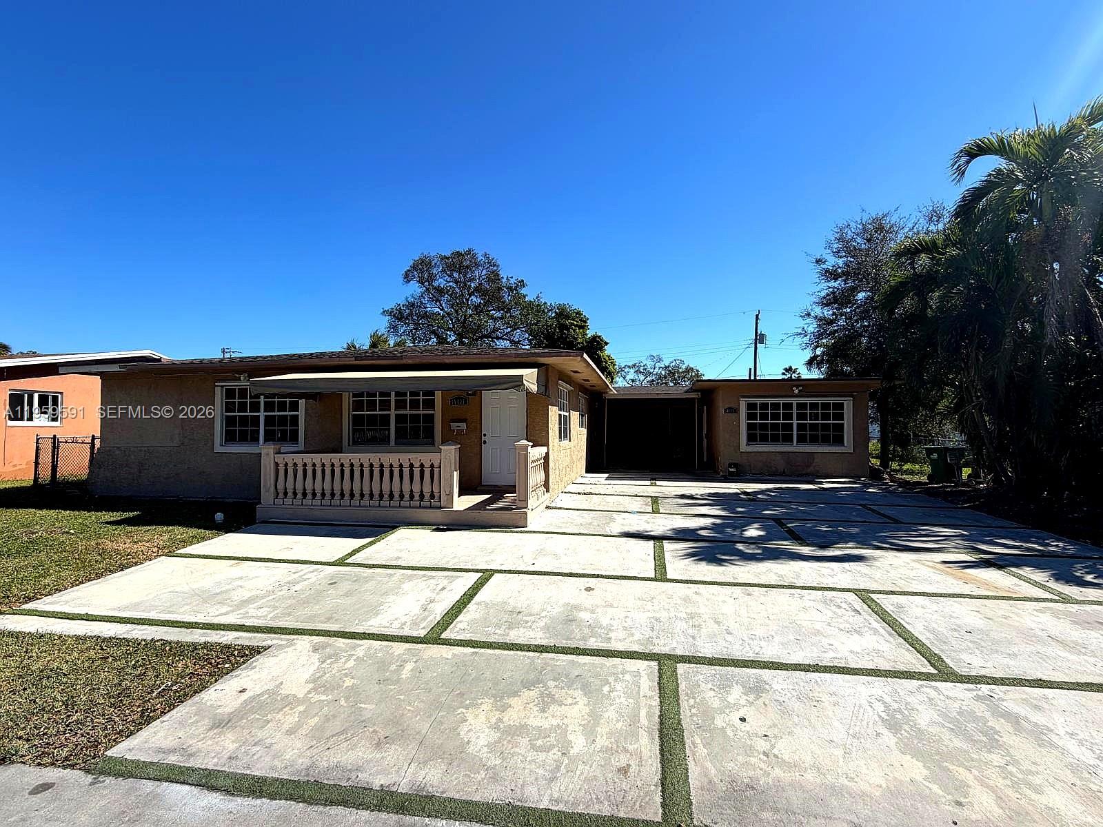 A single-story house features a concrete driveway with grass strips and a small front porch — 14407 NE 5th Ave # 14407, Miami FL 33161, MIAMI, FL