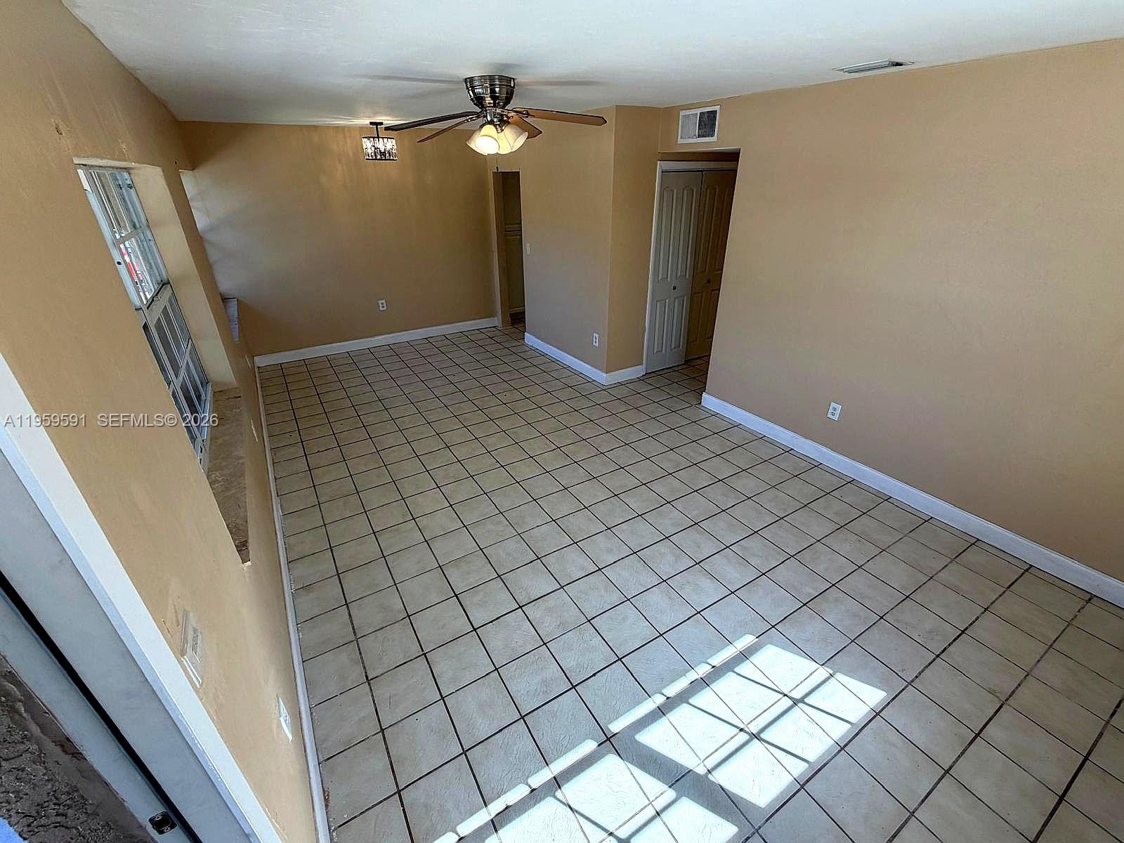 An empty room features beige walls, a tiled floor, a ceiling fan, and a closet — 14407 NE 5th Ave # 14407, Miami FL 33161, MIAMI, FL
