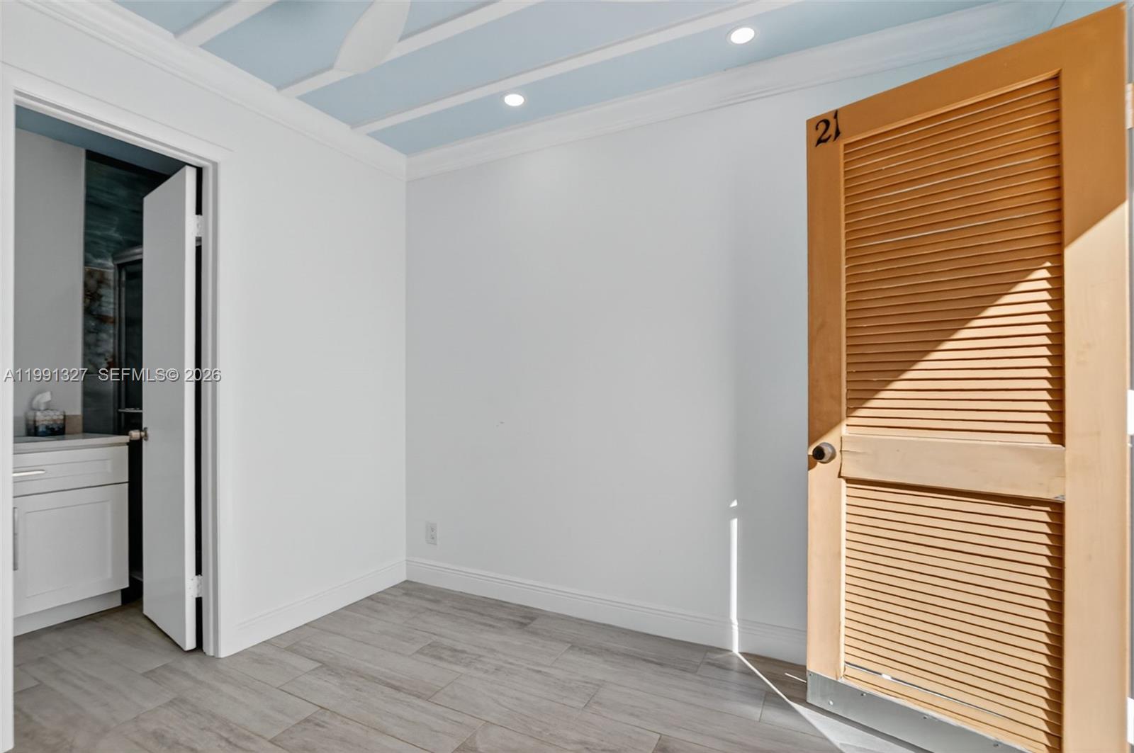 A room with white walls, light wood-look flooring, a louvered door, and a blue ceiling — 7145 Promenade Dr # 702, Boca Raton FL 33433, BOCA RATON, FL