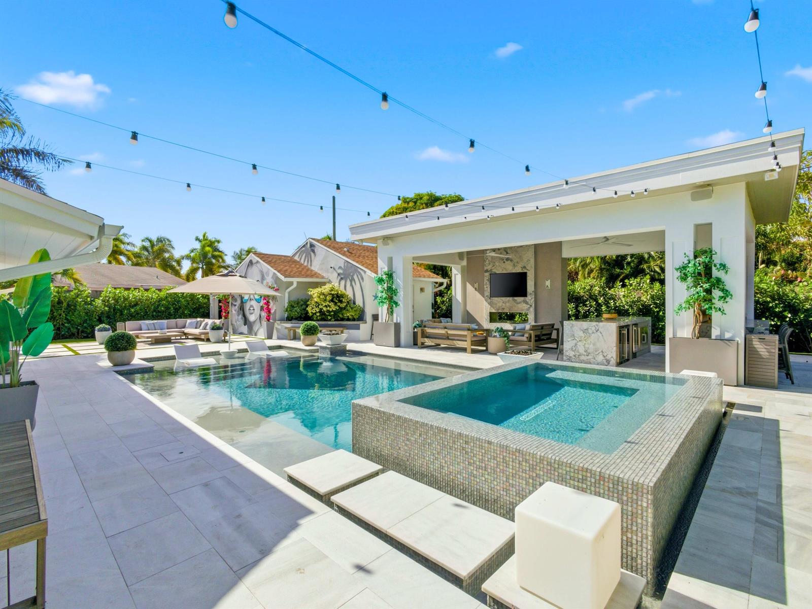 A backyard patio features a swimming pool, a raised spa, and a covered outdoor kitchen — 2210 NE 3rd Ave Avenue, Delray Beach FL 33444, DELRAY BEACH, FL