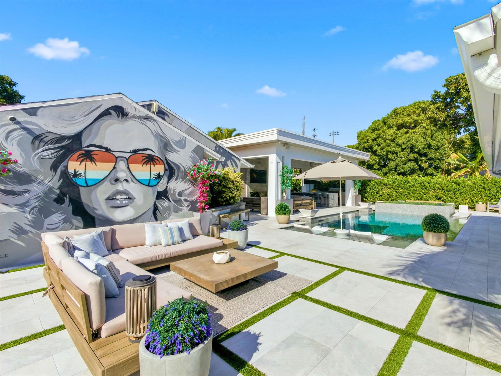 A patio features a large mural, sectional seating, a coffee table, and a swimming pool — 2210 NE 3rd Ave Avenue, Delray Beach FL 33444, DELRAY BEACH, FL