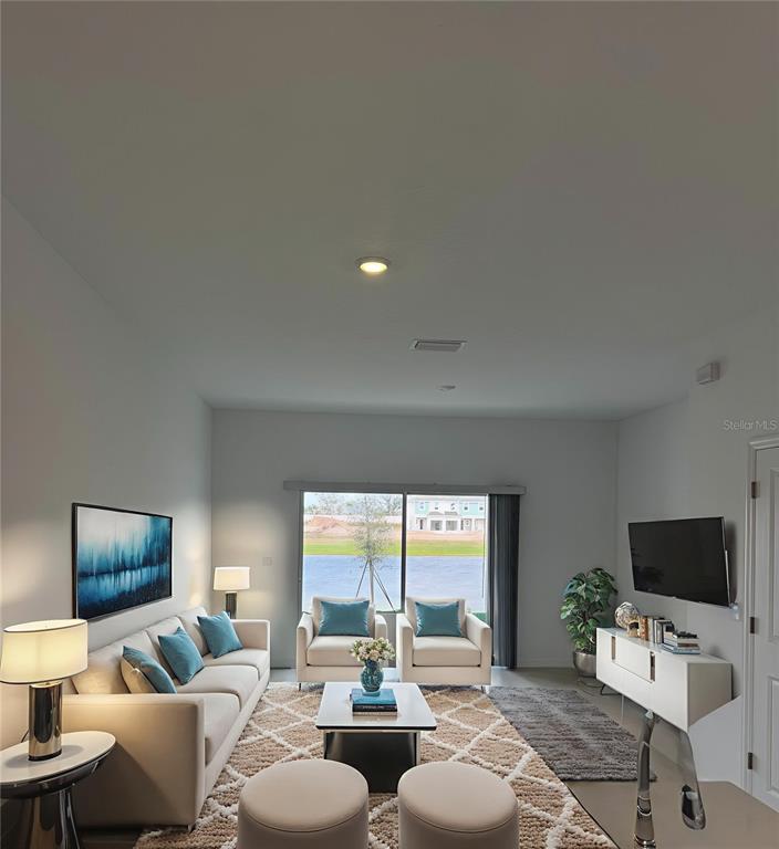 A living room features a sofa, two armchairs, a coffee table, and a wall-mounted television — 16559 SAN NICOLA PLACE, BRADENTON, FL