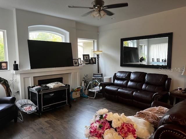 A living room features a fireplace with a television, a leather sofa, and a ceiling fan — 1 GRAYTWIG COURT W, HOMOSASSA, FL