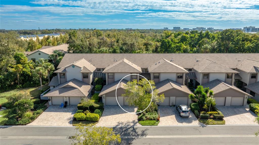 An aerial view of a multi-unit townhouse complex with paver driveways and a central tree — 1648 STARLING DRIVE UNIT 202, SARASOTA, FL
