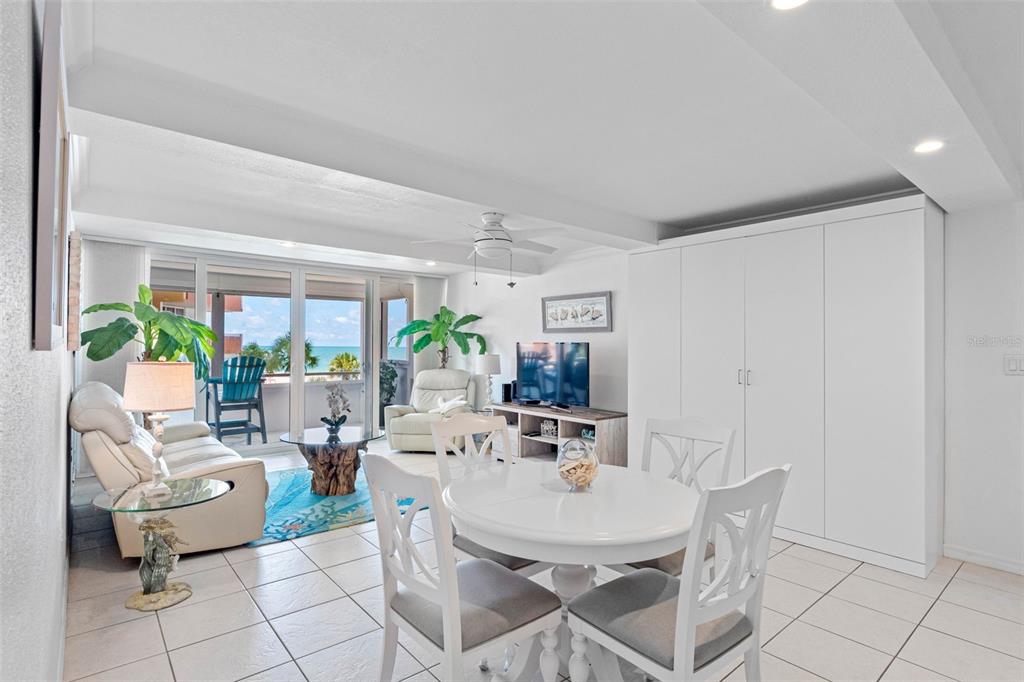 A bright living and dining area features white tile floors, a balcony, and ocean views — 17920 GULF BOULEVARD UNIT 302, REDINGTON SHORES, FL