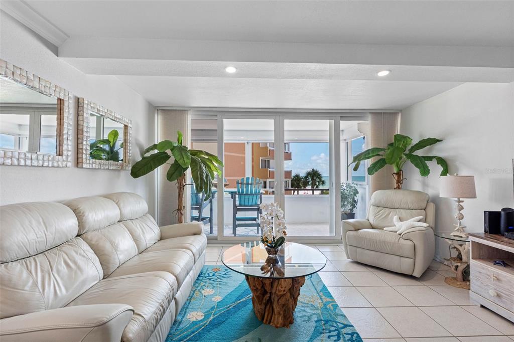 A living room features white leather furniture, a driftwood coffee table, and a balcony view — 17920 GULF BOULEVARD UNIT 302, REDINGTON SHORES, FL