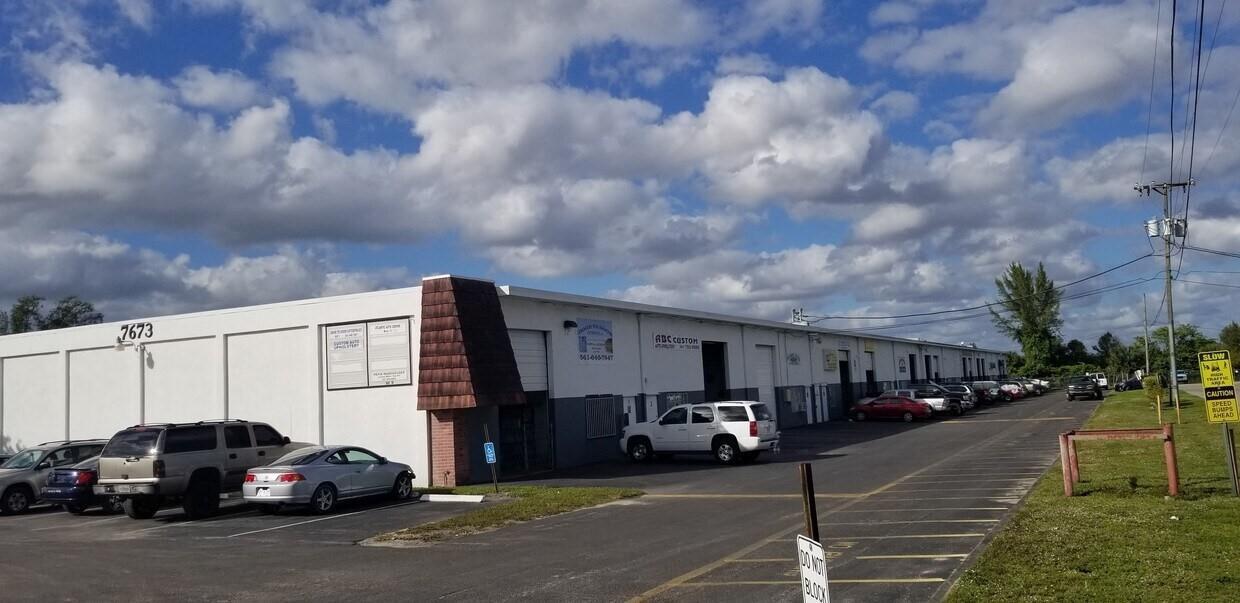 A low-rise commercial building with a white exterior, multiple garage bays, and a parking lot — 7641 Hooper Road, West Palm Beach FL 33411, WEST PALM BEACH, FL