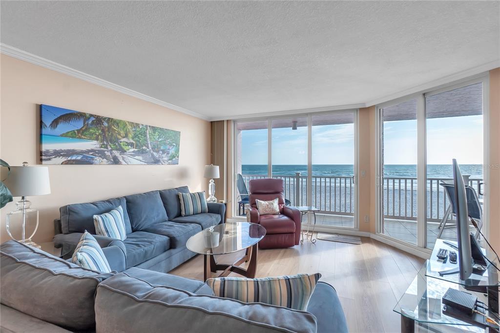 A living room with a blue sectional sofa, a recliner, and a balcony overlooking the ocean — 2600 GULF DRIVE N UNIT 12, BRADENTON BEACH, FL