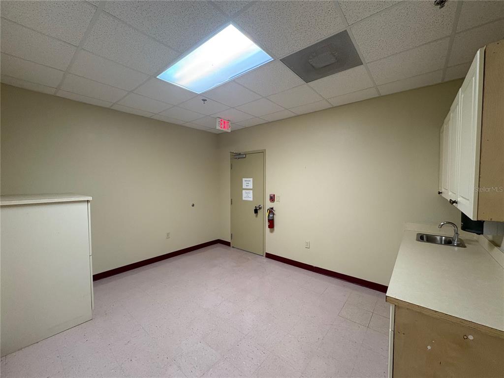 A small office or break room features light-colored walls, a sink, and a fire extinguisher — 13250 N 56TH STREET UNIT 103, TEMPLE TERRACE, FL