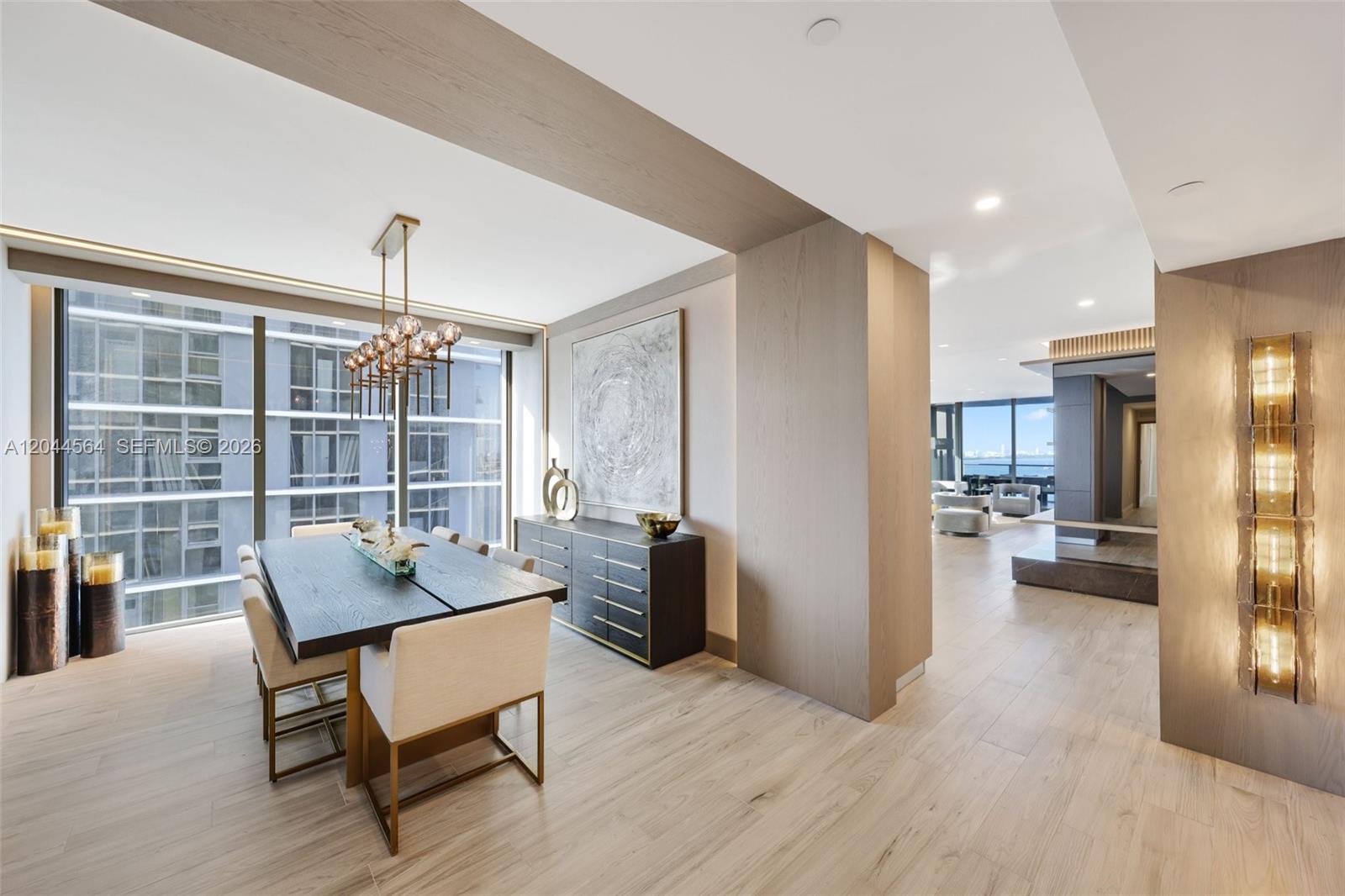 A modern dining room features a dark wood table, upholstered chairs, and floor-to-ceiling windows — 700 NE 24th Street # 1401, Miami FL 33137, MIAMI, FL