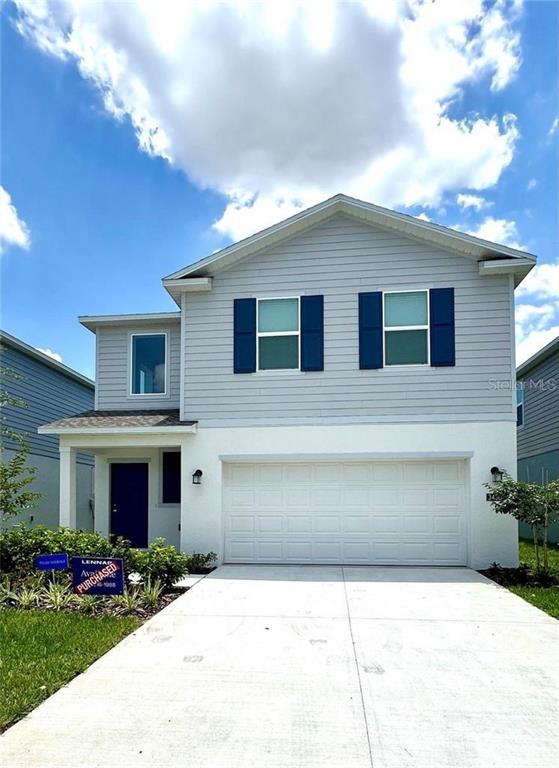 A two-story house features light gray horizontal siding, a white stucco base, and a garage — 3430 HOWELL DRIVE, LAKE WALES, FL