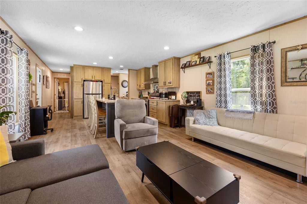 An open-concept living room and kitchen featuring light wood cabinetry, a kitchen island, and furniture — 8444 W JENNIFER COURT, CRYSTAL RIVER, FL