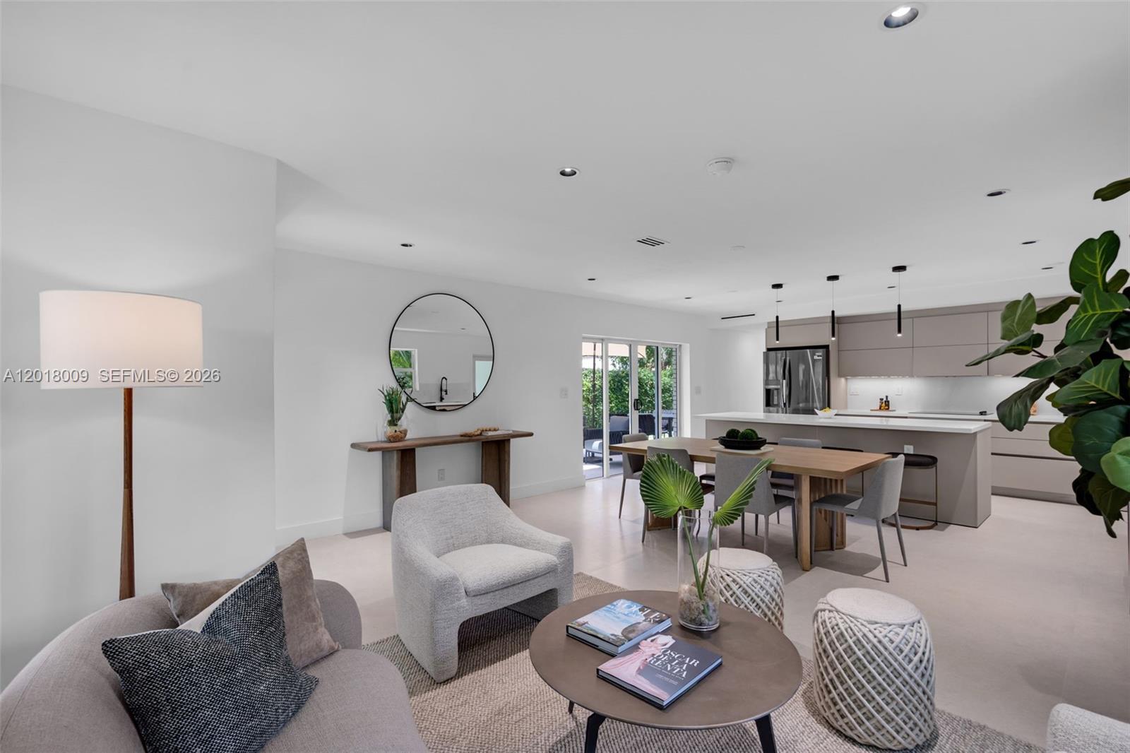 A modern open-concept living and dining area features light tile floors and a neutral kitchen — 1203 Madrid St, Coral Gables FL 33134, CORAL GABLES, FL