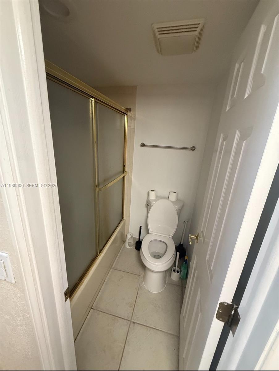 A room with light tile flooring features a pass-through window looking into a kitchen — 9441 Live Oak Pl # 209, Davie FL 33324, DAVIE, FL